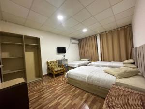 ein Hotelzimmer mit 2 Betten und einem TV in der Unterkunft فندق الروان 