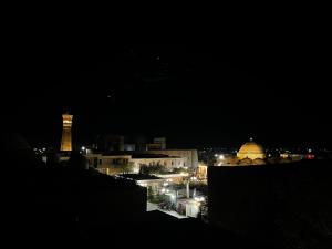 a view of a city at night with a tower at мртапрапвак in Bukhara