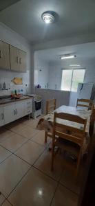 a kitchen with a table and chairs in it at Apartamento Praia Mongagua in Mongaguá