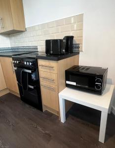 a kitchen with a black stove and a microwave at AP Apartment in Glasgow