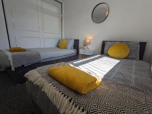sypialnia z 2 łóżkami i żółtym kocem w obiekcie Hs UK Homes Beautiful 2 bed in Bradford w mieście Bradford