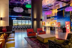 a lobby with chairs and a bar with clouds at Aloft Panama in Panama City