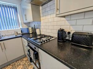 a kitchen with a stove and a counter top at Hs UK Homes Beautiful 2 bed in Bradford in Bradford