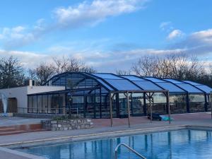 un bâtiment avec une piscine devant dans l'établissement Chaussy55, à Lagorce
