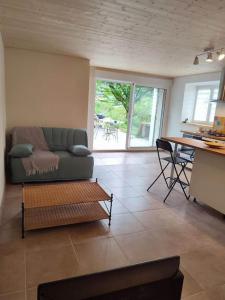 een woonkamer met een bank en een tafel bij Logement avec terrasse Millau in Millau