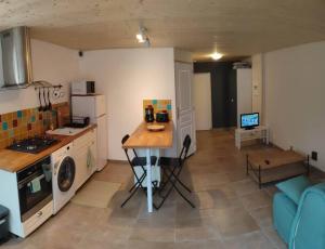 a kitchen with a table in the middle of a room at Logement avec terrasse Millau in Millau +4 photos