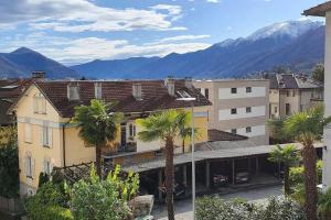 a city with palm trees and mountains in the background at Apartment via San Carlo in Muralto-Locarno in Muralto