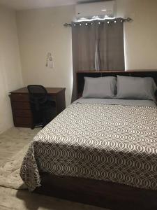Schlafzimmer mit einem Bett, einer Kommode und einem Schreibtisch in der Unterkunft SkylineSuites Lost in Paradise - FA3 in Grand Anse