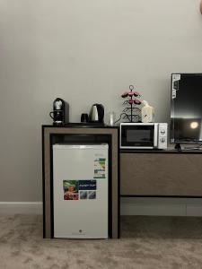 a microwave and a refrigerator next to a counter at سكون الفاخرة - دخول ذاتي in As Sayl aş Şaghīr