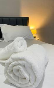 une pile de serviettes blanches assises sur un lit dans l'établissement Cosy, private apartment in a family villa, à Tirana