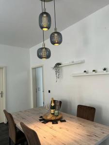 een eetkamer met een houten tafel met stoelen en verlichting bij City Vibe Zentrum Zwickau in Zwickau