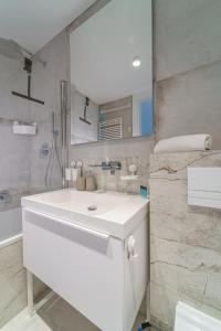 ein weißes Badezimmer mit einem Waschbecken und einem Spiegel in der Unterkunft Apartament Świeradowiec MountainAparts in Świeradów-Zdrój