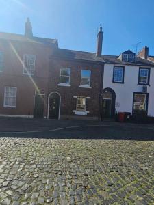 a cobblestone street in front of a house at Carlisle City Centre. The Foremans Residence. in Carlisle