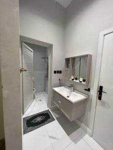 a white bathroom with a sink and a shower at سكون الفاخرة - دخول ذاتي in As Sayl aş Şaghīr