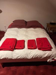 a bed with four red towels on it at Maison bonheur proche GIVERNY et top pour télétravail in Haute-Isle