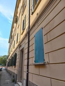 un bâtiment avec une fenêtre bleue sur son côté dans l'établissement Appartamento Mercante in Fiera BO con posto auto, à Bologne