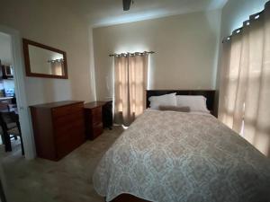a bedroom with a bed and a desk and a mirror at SkylineSuites Lost in Paradise - FA4 in Grand Anse