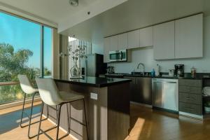 a kitchen with white cabinets and a counter with stools at Modern Luxury 2 Bd Apt with Pool Views and free parking in Los Angeles