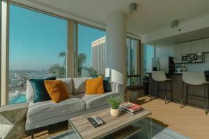 een woonkamer met een bank en een groot raam bij Modern Luxury 2 Bd Apt with Pool Views and free parking in Los Angeles