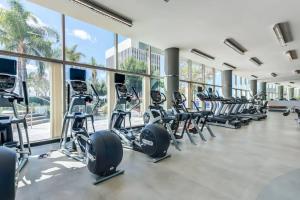 a gym with rows of treadmills and elliptical machines at Modern Luxury 2 Bd Apt with Pool Views and free parking in Los Angeles