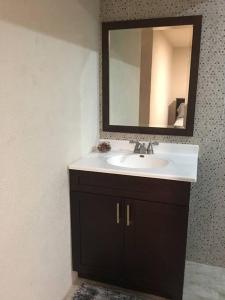 a bathroom with a sink and a mirror at SkylineSuites Lost in Paradise - FA4 in Grand Anse