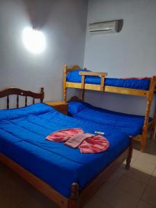 um quarto com 2 beliches e lençóis azuis em Fatme Hotel em San Agustín de Valle Fértil