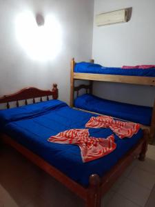 twee bedden in een kamer met blauwe lakens bij Fatme Hotel in San Agustín de Valle Fértil