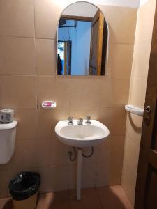 een badkamer met een wastafel en een spiegel bij Fatme Hotel in San Agustín de Valle Fértil