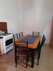 een tafel en stoelen in een keuken met een fornuis bij Fatme Hotel in San Agustín de Valle Fértil