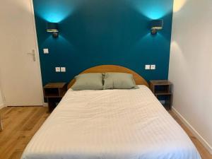a bedroom with a large bed with a blue wall at Aubervilliers Paris in Aubervilliers