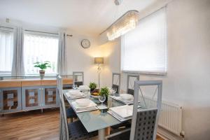 a dining room with a glass table and chairs at Rawmarsh House, Rotherham for Contractors, Business & families -Monthly Discount in Rotherham