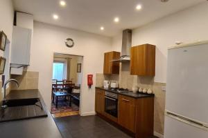 una cucina con armadi in legno e piano cottura. di A spacious and well equipped 4 bedroom house a Portsmouth