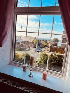 a window with two candles sitting on a window sill at Willow Cottage - Billinge Wigan, sleeps 4 , parking and garden in Billinge
