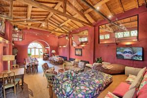 una gran sala de estar con paredes rojas y techos de madera. en La Pimpinella di Semifonte, en San Donnino