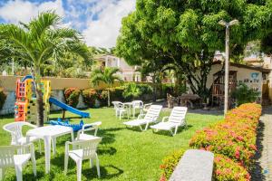 a playground with white chairs and a slide at Pousada Tropicalia in Itaparica