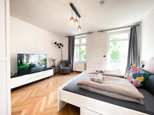 Schlafzimmer mit einem Bett und einem Flachbild-TV in der Unterkunft Zentrale Ferienwohnung mit Parkplatz, 2 Schlafzimmern, Küche, Waschmaschine & Balkon in Leipzig