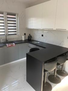 a kitchen with a black counter and white cabinets at Biebrzańska Przystań in Goniadz