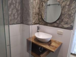 a bathroom with a sink and a mirror at HOSTEL LA CASA DE PETRA in Santa Marta