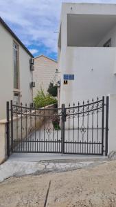 a black iron gate in front of a white building at Apartments Slavica in Bol