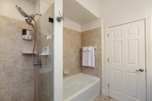 a bathroom with a shower and a bath tub with a shower at The Lumber Baron's Mansion: 2 King Suites, 2.5BA + Gym in Detroit