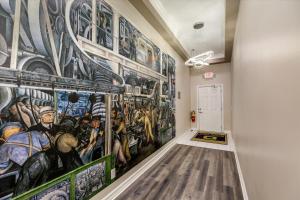 a hallway with a large painting on the wall at The Lumber Baron's Mansion: 2 King Suites, 2.5BA + Gym in Detroit