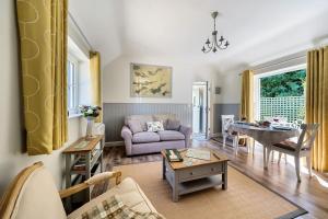 a living room with a couch and a table at Stable Cottage in Dorchester