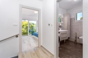 a white bathroom with a sink and a mirror at Holiday house Bibi in Punat +36 photos