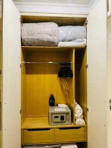 a room with a closet with a microwave and towels at Flat Congonhas in São Paulo