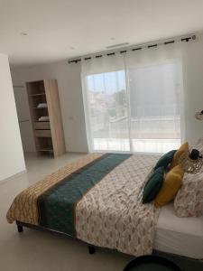 a bedroom with a large bed and a large window at Maison Bella in Empuriabrava