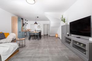 a living room with a large television and a kitchen at Holiday house Bibi in Punat