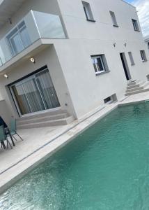 艾姆布里亞布拉瓦的住宿－Maison Bella，房屋前有游泳池的房子