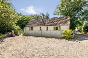 a house with a fence in front of it at Stable Cottage in Dorchester