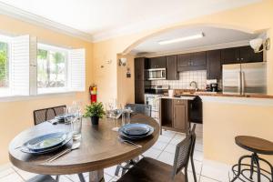 cocina y comedor con mesa de madera y sillas en Tropical Paradise en Fort Lauderdale