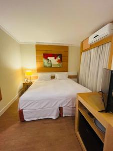 a hotel room with a bed and a television at Flat Congonhas in São Paulo